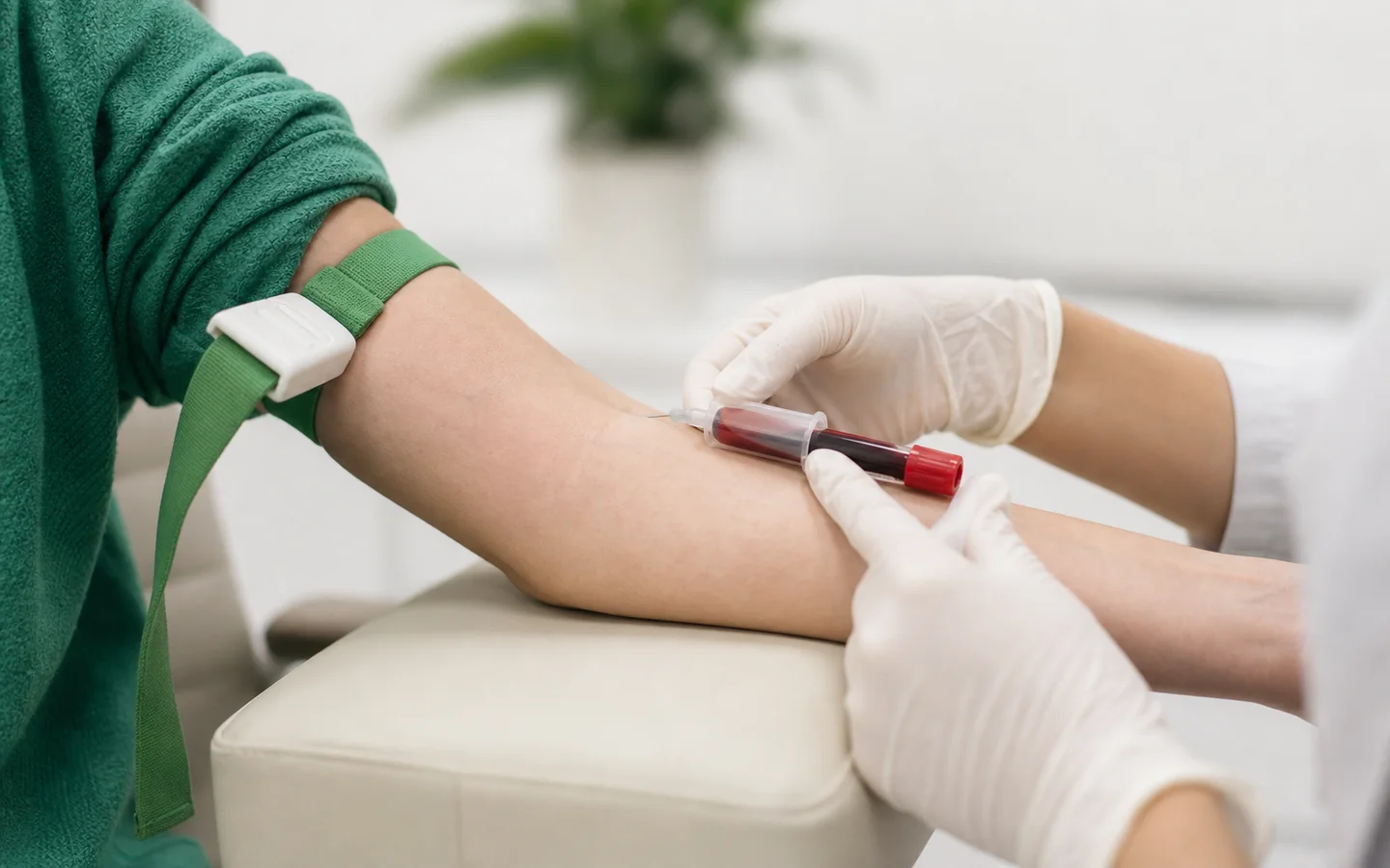 A clinician drawing a blood sample into a collection tube