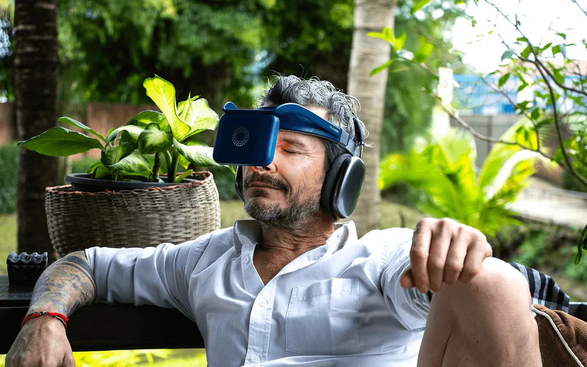 Man wearing a NeuroVIZR light device and headphones outdoors